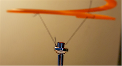 Cotton thread clamped to the top of the screwdriver by a small magnet